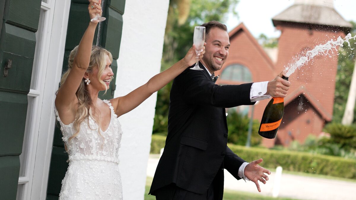 Bride and groom spraying champagne as they celebrate, a still from an Aurora Adeleigh wedding film
