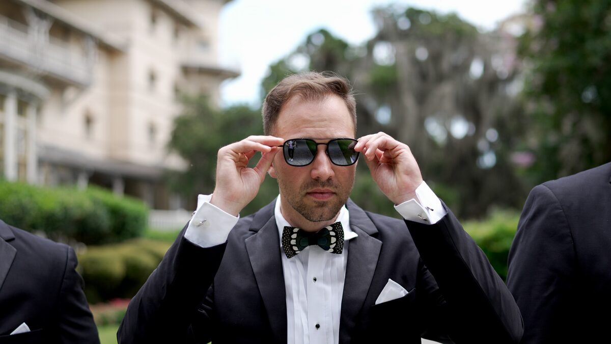 Groom putting on sunglasses before the ceremony, a still from a wedding film