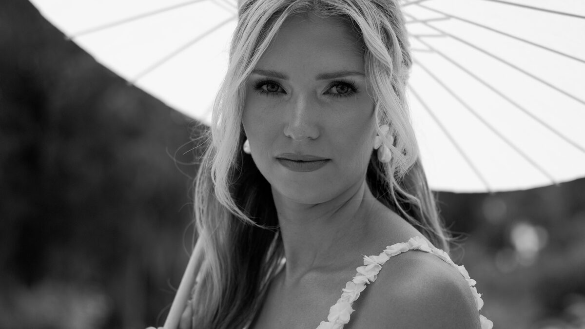 Black and white film still of a bride beneath a paper parasol, Aurora Adeleigh, Augusta GA wedding videographer