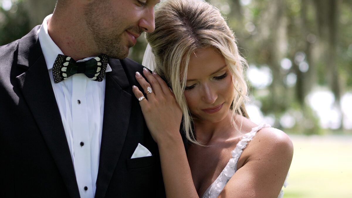 Bride resting her head on the groom’s shoulder, a still from a wedding film