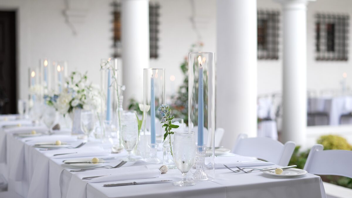 Reception tablescape with candles and pale blue taper candles on a veranda