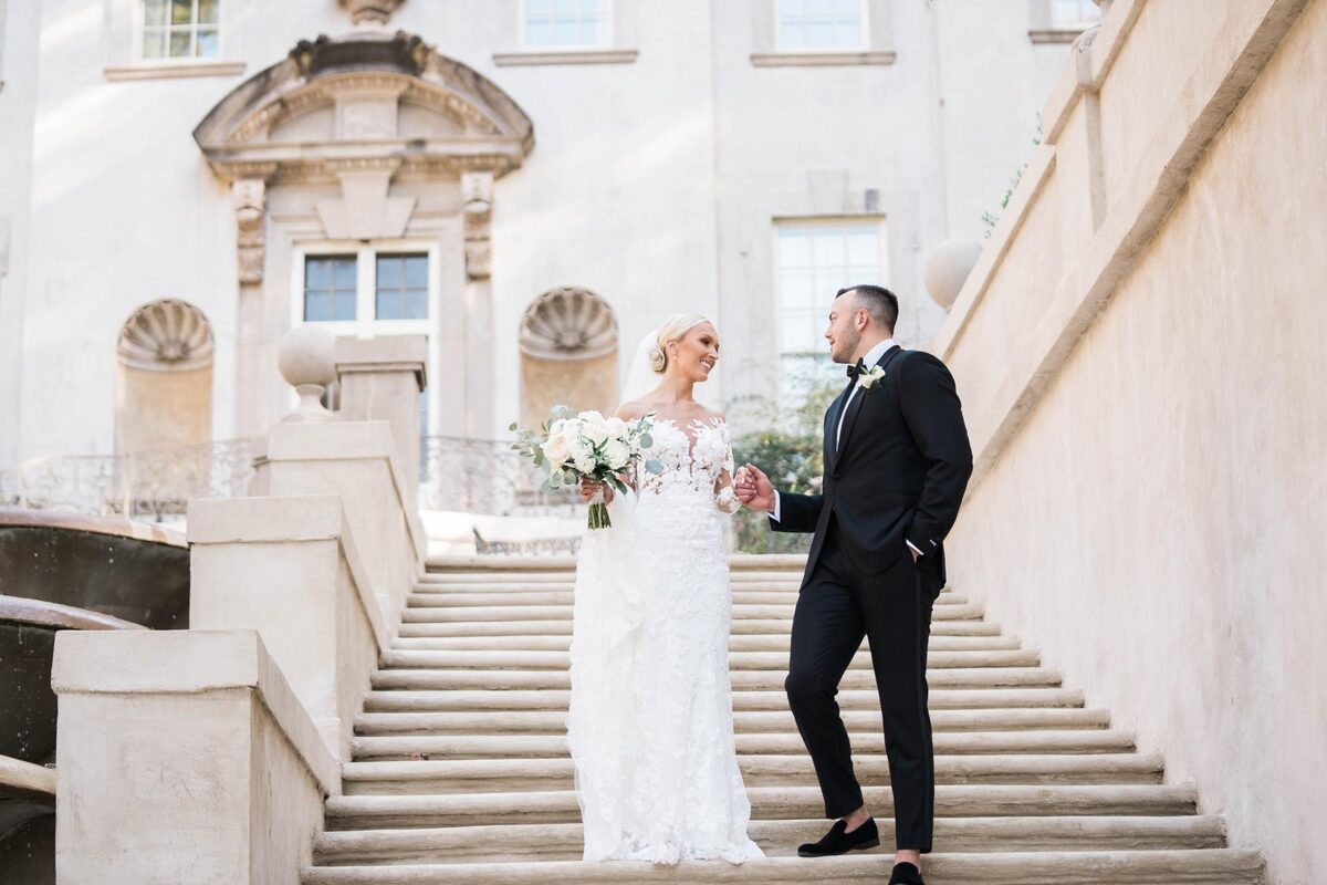 Bride and groom on a grand outdoor stone staircase