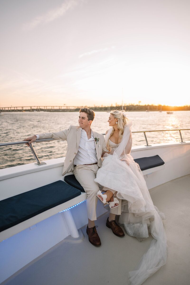 Bride and groom on a boat at sunset, award-winning wedding photography by Aurora Adeleigh
