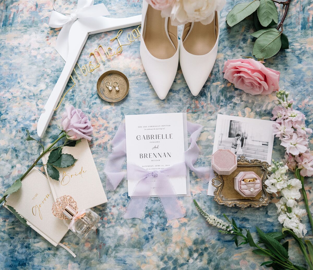 Wedding invitation suite, bridal shoes, rings and keepsakes laid flat, wedding detail photography