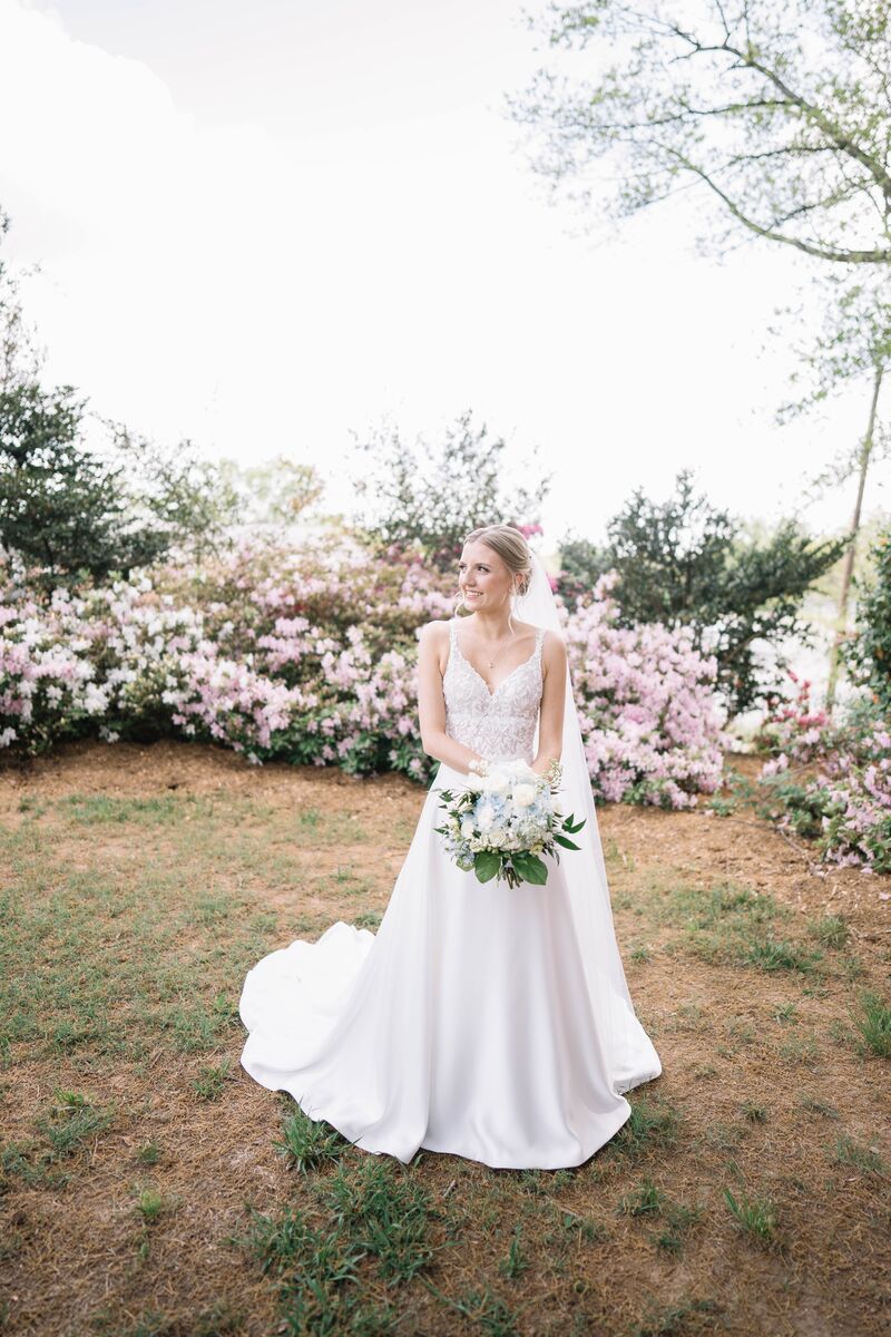 Bride with her bouquet before blooming azaleas