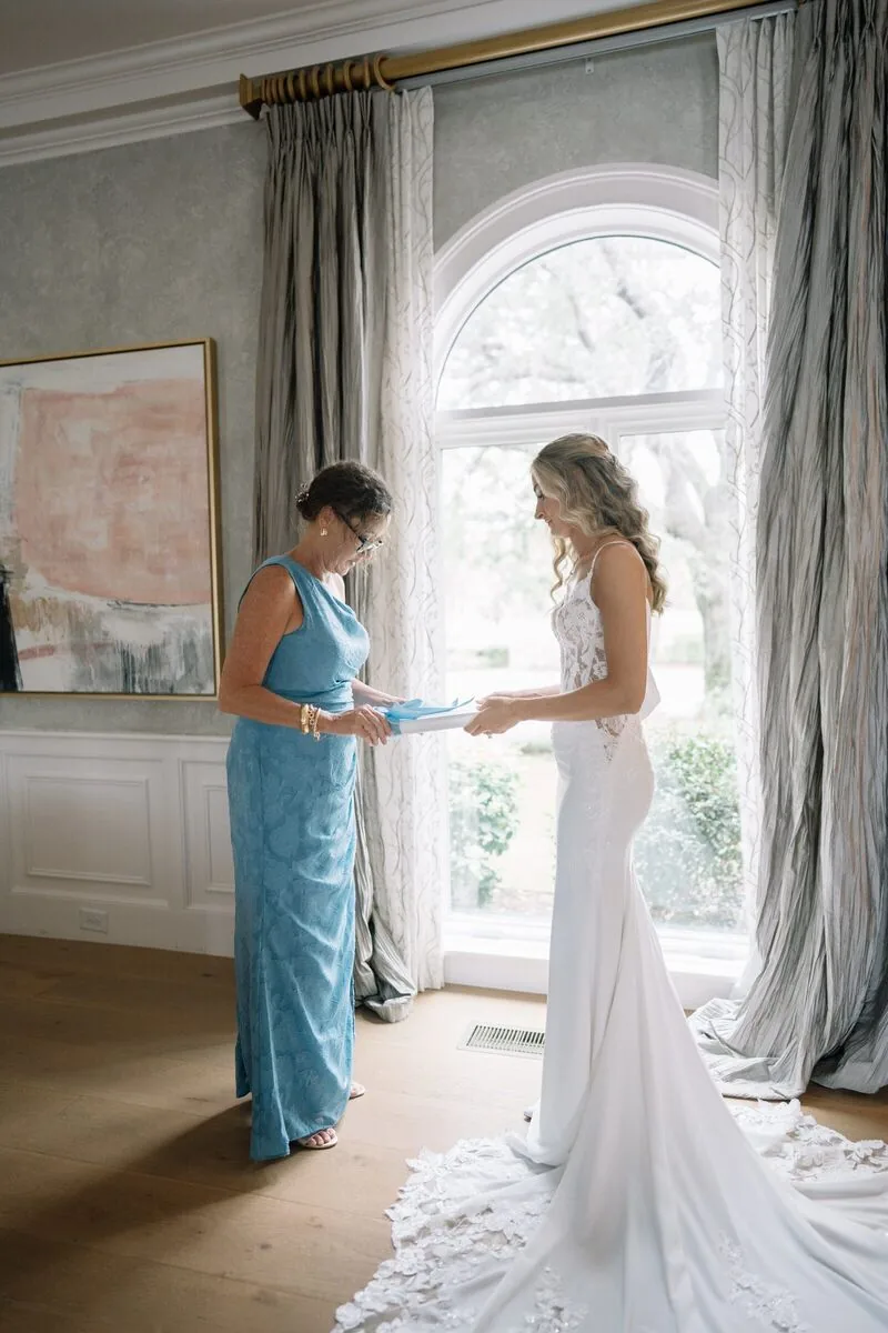 A loved one handing the bride a gift on her wedding morning