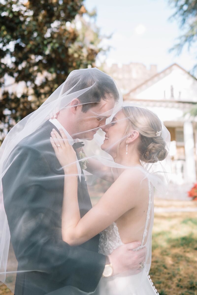 Bride and groom about to kiss beneath her veil