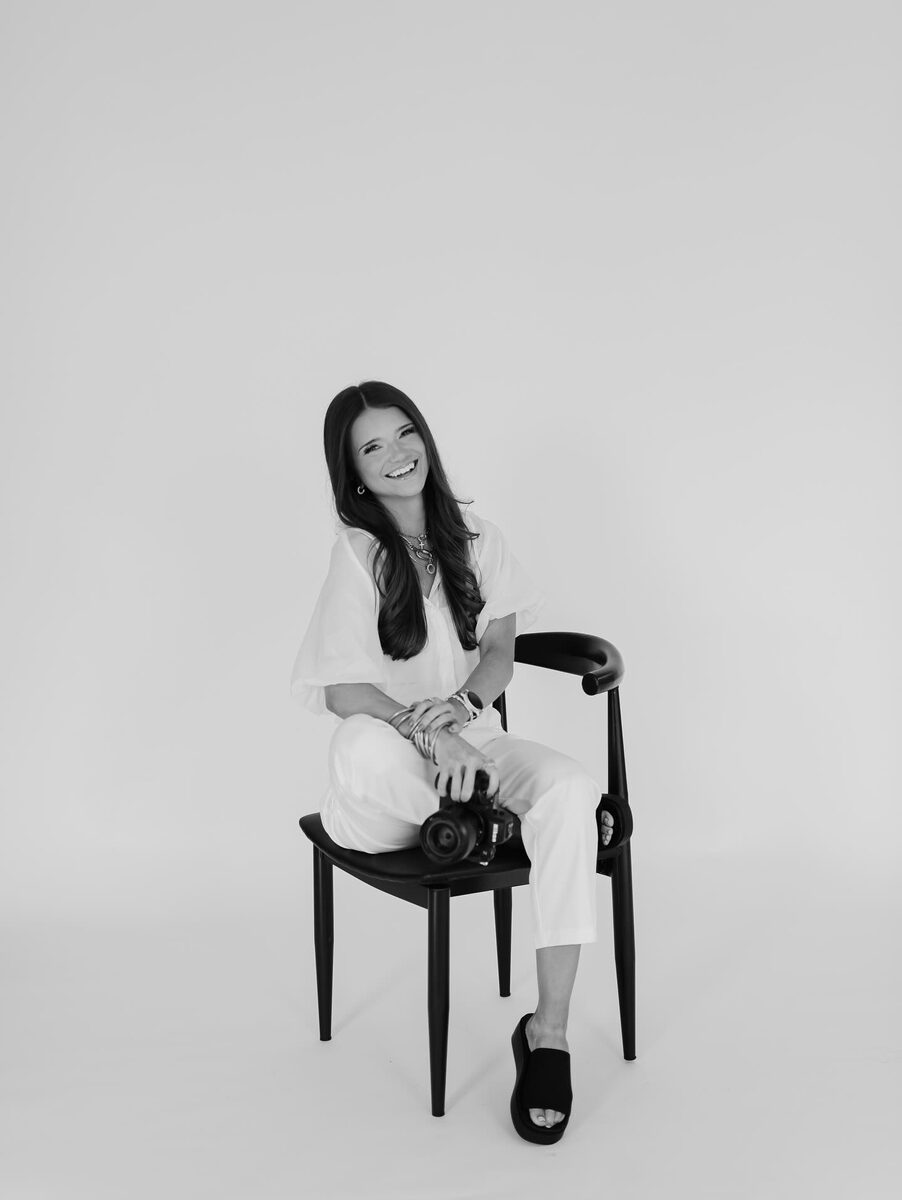 Kellyn, lead photographer at Aurora Adeleigh, seated with her camera